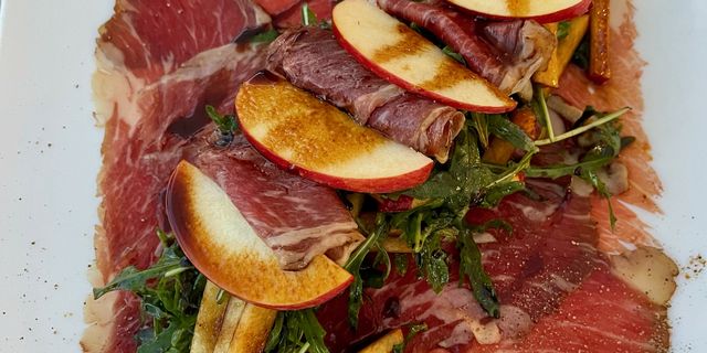 Beef carpaccio with arugula and nectarine slices at an Italian restaurant